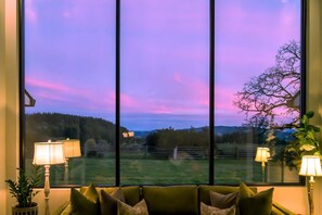 Ein Zimmer mit einem großen Fenster, einem Sofa und zwei Lampen.