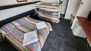 Une chambre d’hôtel avec deux lits superposés, un bureau, une chaise et une petite table.