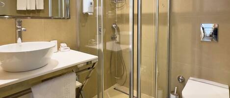 Une salle de bain moderne avec une douche à parois de verre, un lavabo et des toilettes.