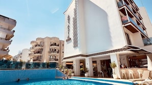 A hotel with a swimming pool, a bar area, and a view of other buildings. - Aurasia Design Hotel (Marmaris)