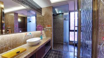 Une salle de bain moderne avec un grand miroir, un lavabo blanc et un espace douche.