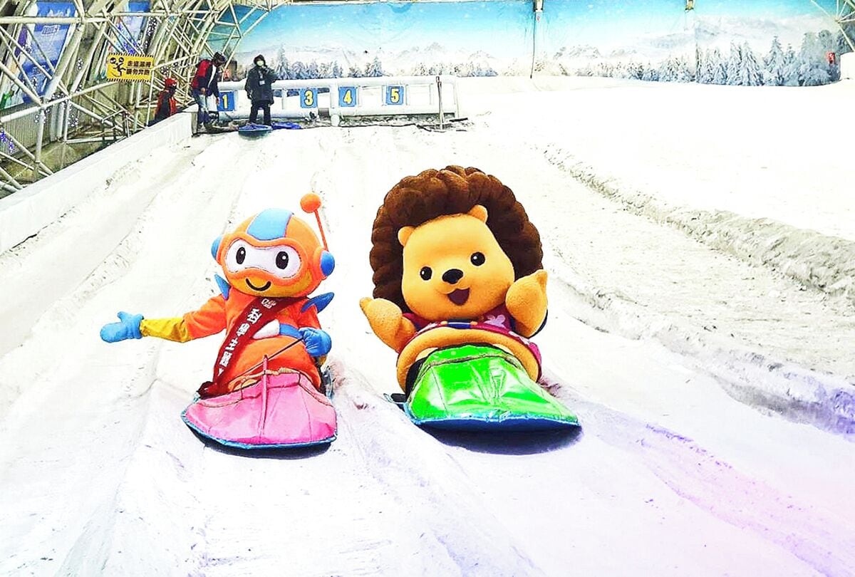 Two large plush toys on a snowy slope, likely part of a winter attraction.