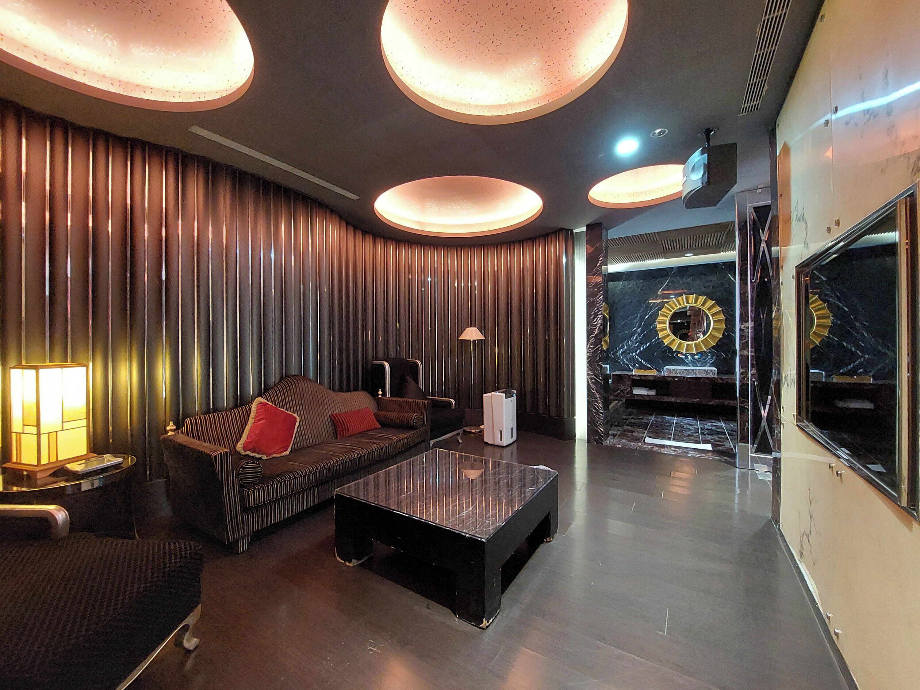 A modern lounge area with a sofa, a coffee table, and a lamp.