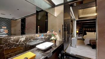 Un baño moderno con encimera de mármol, un lavabo blanco y un espejo.