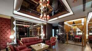 A spacious lobby with a red leather sofa set, a glass coffee table, and a chandelier. - ELYSEES MOTEL (Toufen)