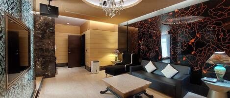 A modern living room with a chandelier, a sofa set, a coffee table, and a decorative wall.