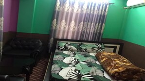 A room with a bed, a chair, and a window with curtains. - MeroStay 010 Miracle Hotel Lodge and Restaurant (Kathmandu)