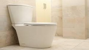 A white toilet in a bathroom with beige tiles. - MeroStay 010 Miracle Hotel Lodge and Restaurant (Kathmandu)