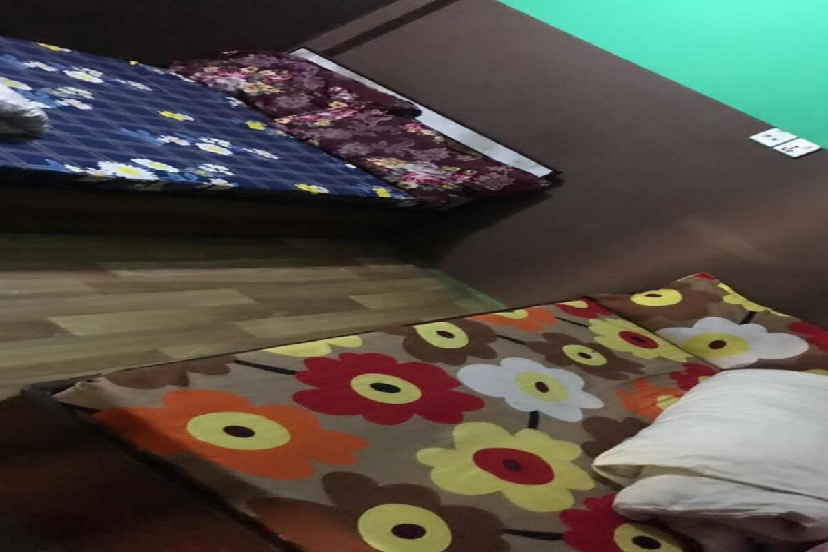 Ein Zimmer mit einem Bett, einem Kissen und einem kleinen Tisch.