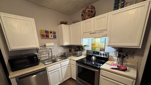 A modern kitchen with white cabinets, stainless steel appliances, a dishwasher, an oven, and a toaster. - Rose Music House- 8 min from Broadway (Nashville)