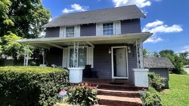 A two-story house with a porch, a front door, and a small garden area. - Rose Music House- 8 min from Broadway (Nashville)