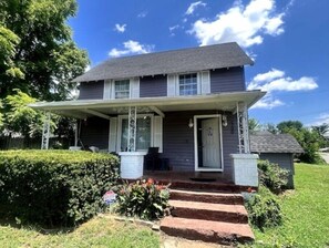 A two-story house with a porch, a front door, and a small garden area. - Rose Music House- 8 min from Broadway (Nashville)
