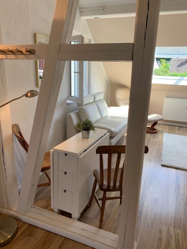 A compact, modern bedroom with a loft-style bed, a small desk, and a chair.