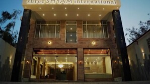 Een gebouw met het bord 'shree SHYAM international', wat aangeeft dat het een hotel is.