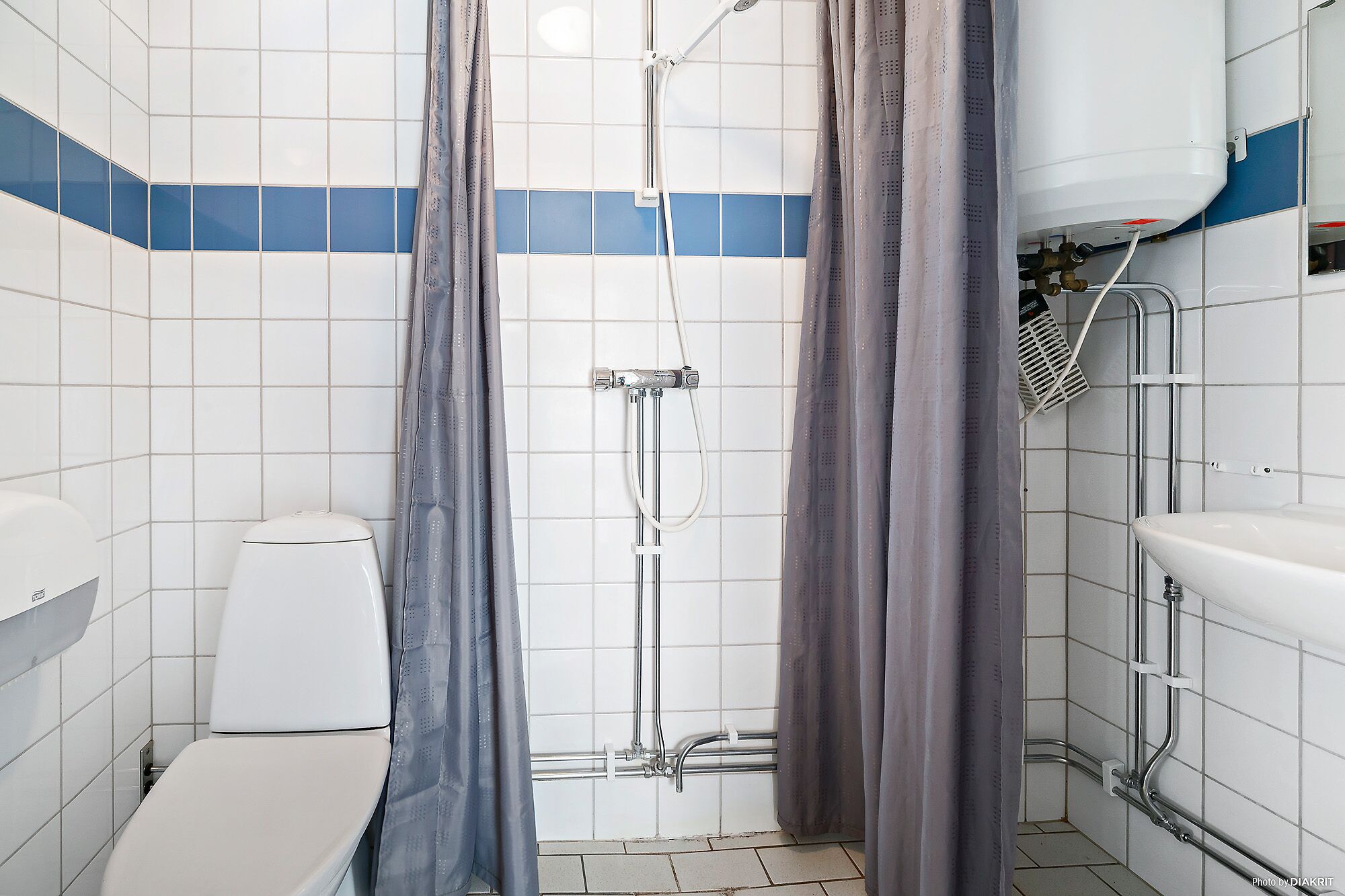 A bathroom with a shower, toilet, and sink.