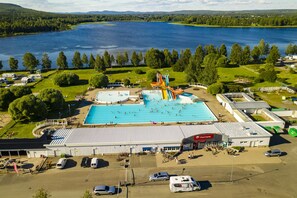 An aerial view of a water park with a swimming pool, slides, and a parking area. - First Camp Björknäs Boden (Boden)