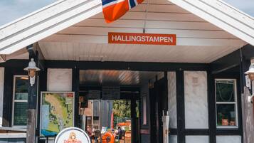 A building entrance with a sign reading "HALLINGSTAMPEN" and a map on the wall.
