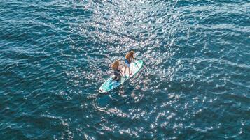 A person paddleboarding on a body of water.