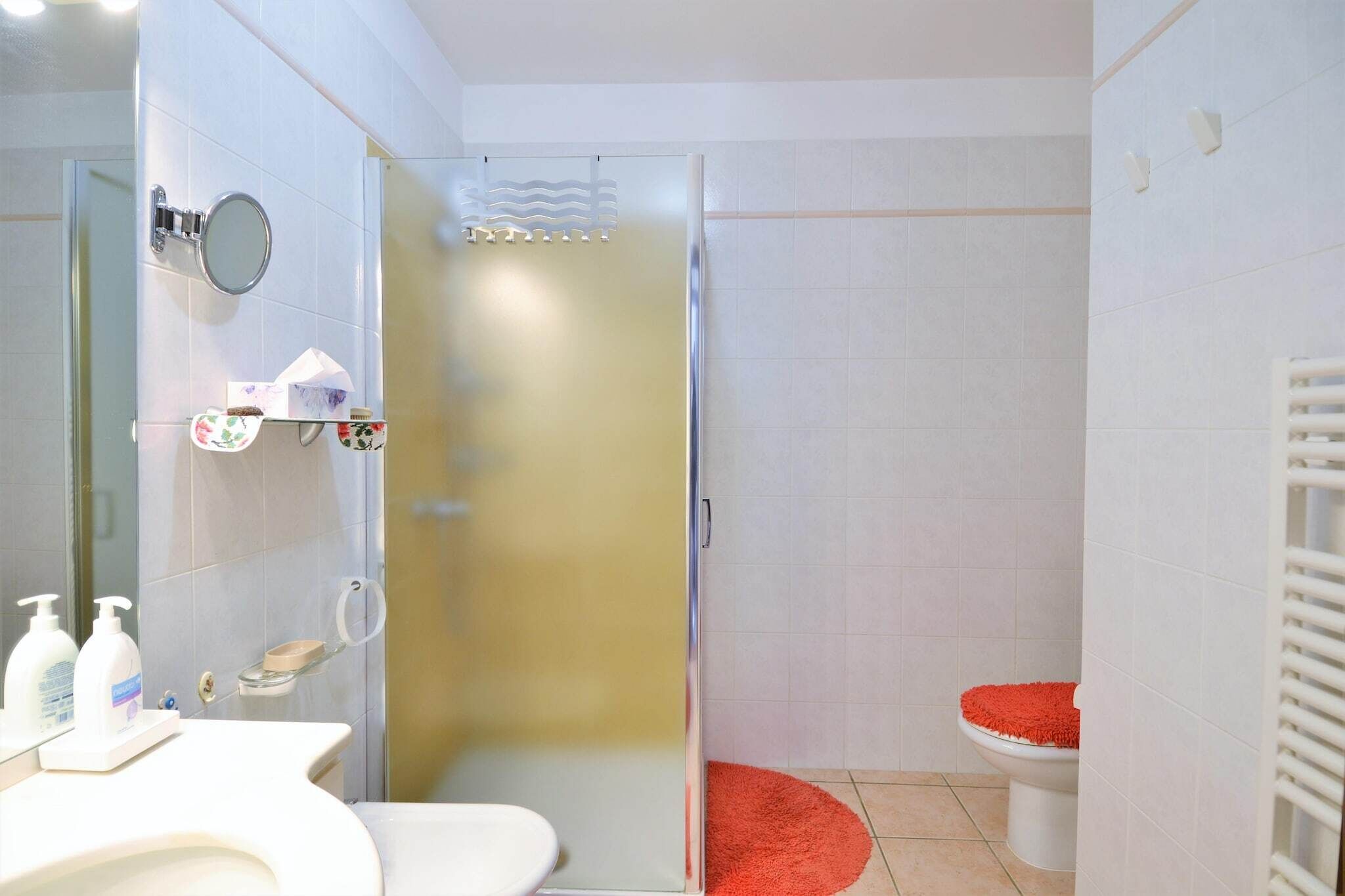 A bathroom with a toilet, sink, and shower area.