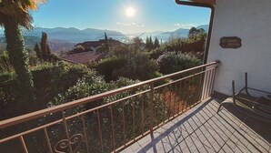 Ein Balkon mit Metallgeländer mit Blick auf eine gebirgige Landschaft.