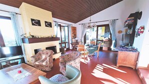 Ein Wohnzimmer mit Kamin, Holzmöbeln und einem Fernseher.
