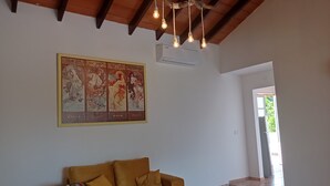 Ein Zimmer mit Holzboden, einem großen Wandteppich, einer Couch und einem gemusterten Boden.