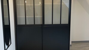 Un juego de puertas dobles con un panel de vidrio satinado y un marco negro sólido.
