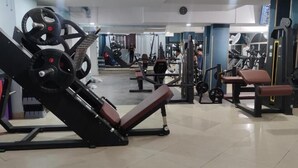 A gym with various exercise equipment, including weight machines and benches. - DOWNTOWN HOTEL (Antananarivo)