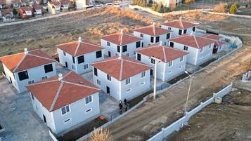 Una zona residencial con varias casas blancas con techos de tejas rojas, dispuestas en hilera.