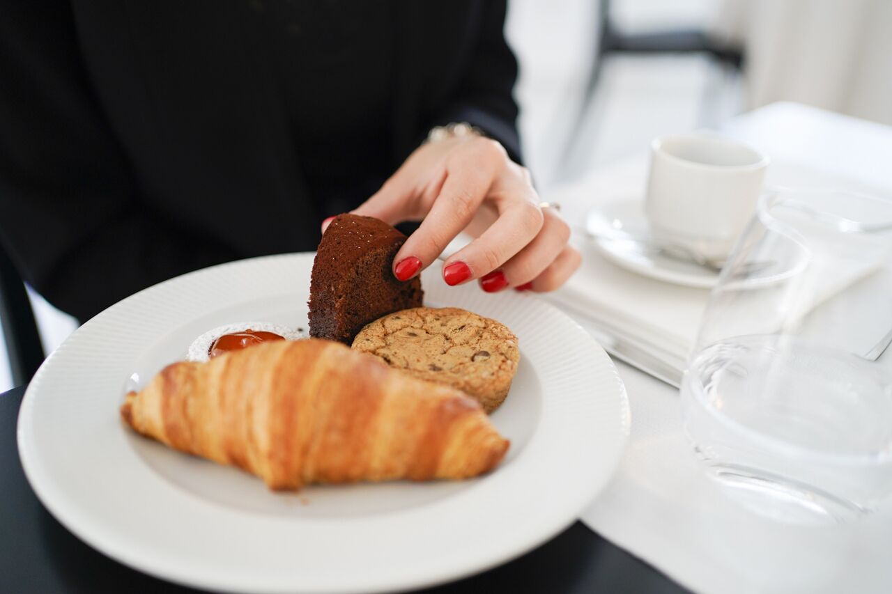 Un plato con un croissant, un pastel de chocolate y una galleta.