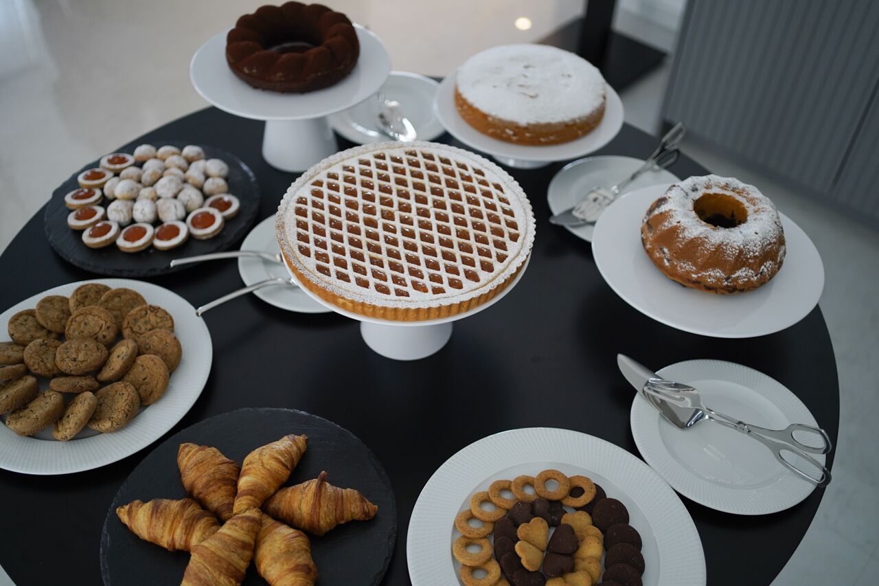 Une table où sont présentés divers desserts, notamment des gâteaux, des biscuits et des pâtisseries.