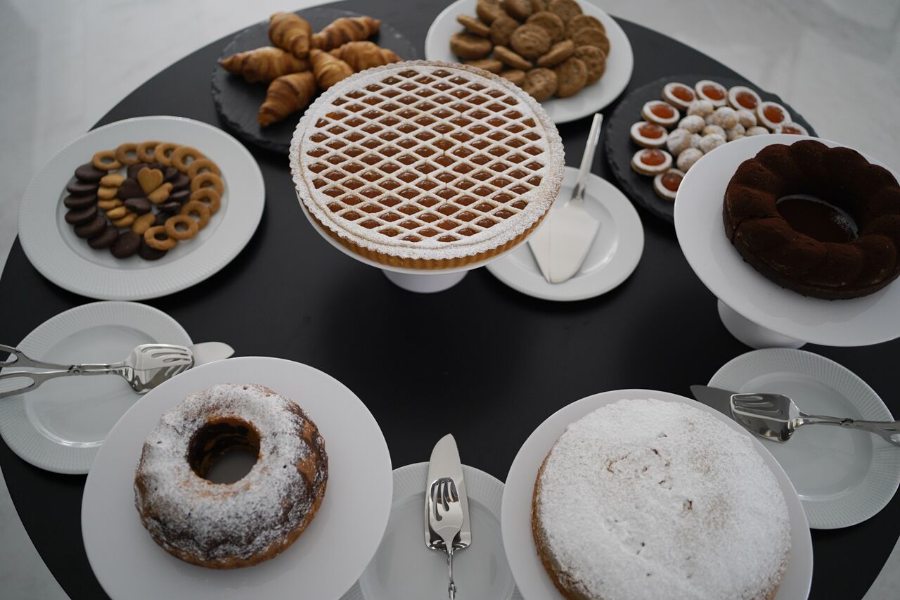 Una mesa con diversos postres y pasteles dispuestos en platos.