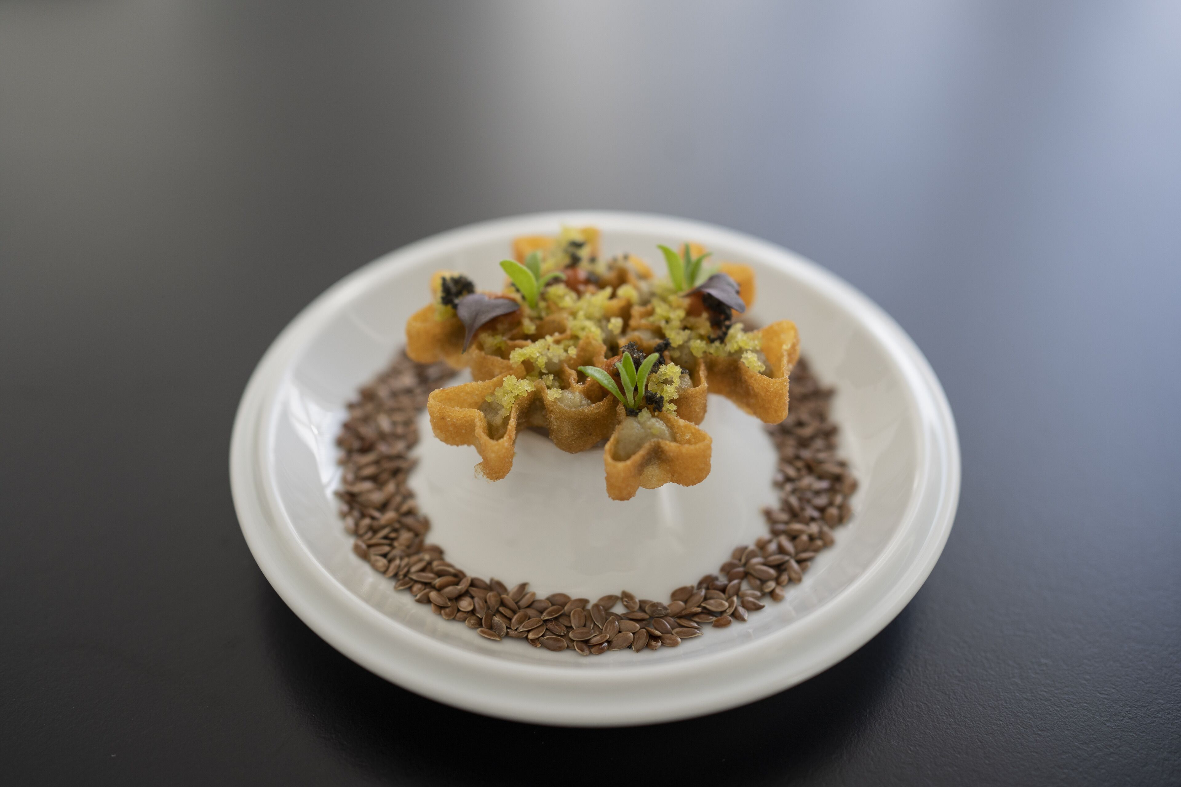 A white plate with a food arrangement on a dark surface.
