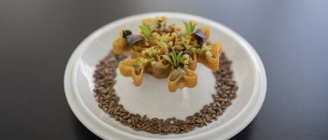 A white plate with a food arrangement on a dark surface.