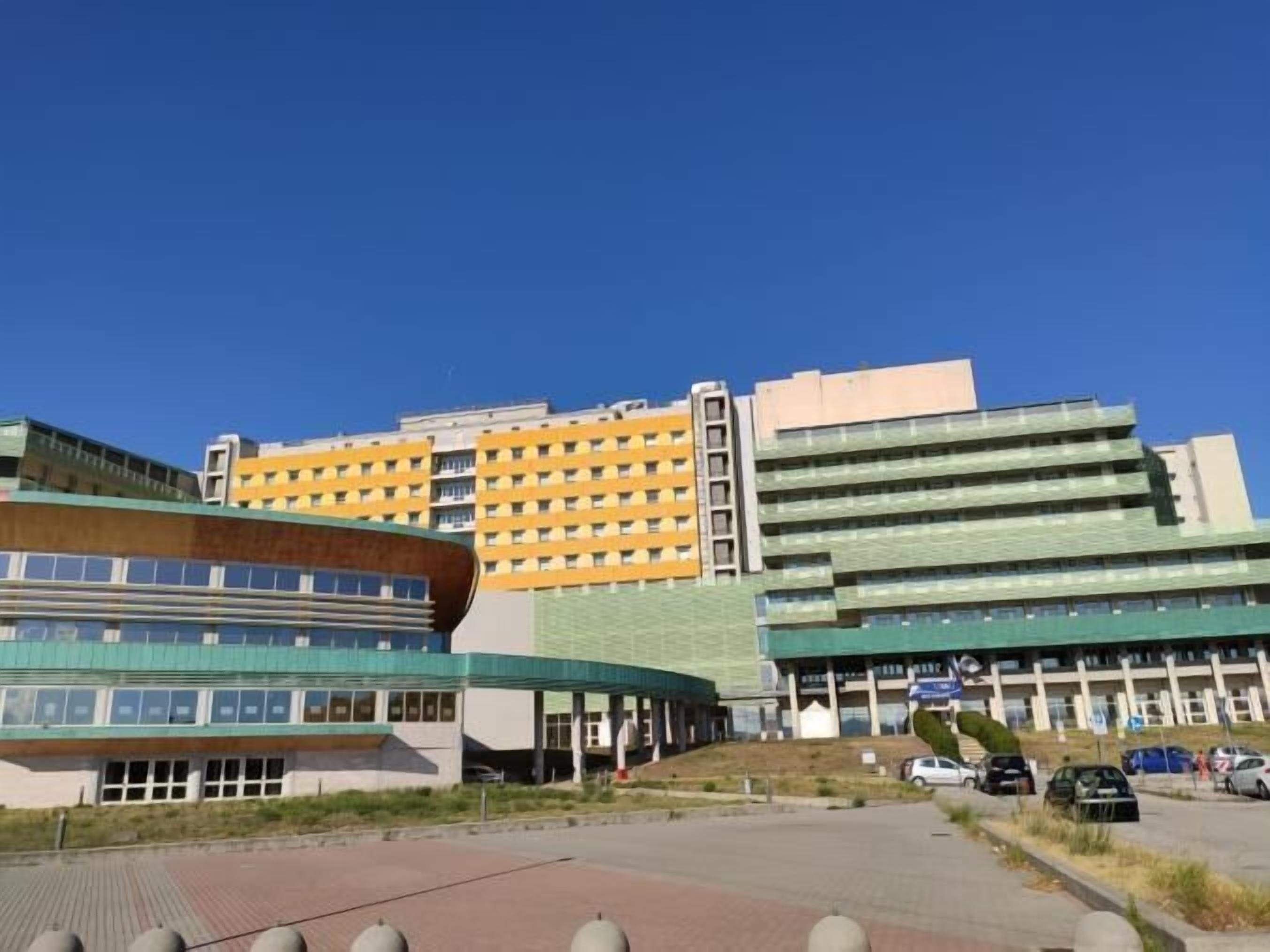 A modern building with a curved facade, multiple floors, and a flat roof.