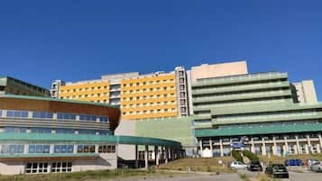 A modern building with a curved facade, multiple floors, and a flat roof.