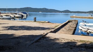 Una marina con imbarcazioni ormeggiate, acqua calma e cielo sereno.