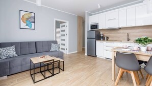 A modern kitchen with white cabinets, a microwave, and a refrigerator. - Climate Apartment | Balcony, Parking, 500 m to the Beach (Miedzywodzie)