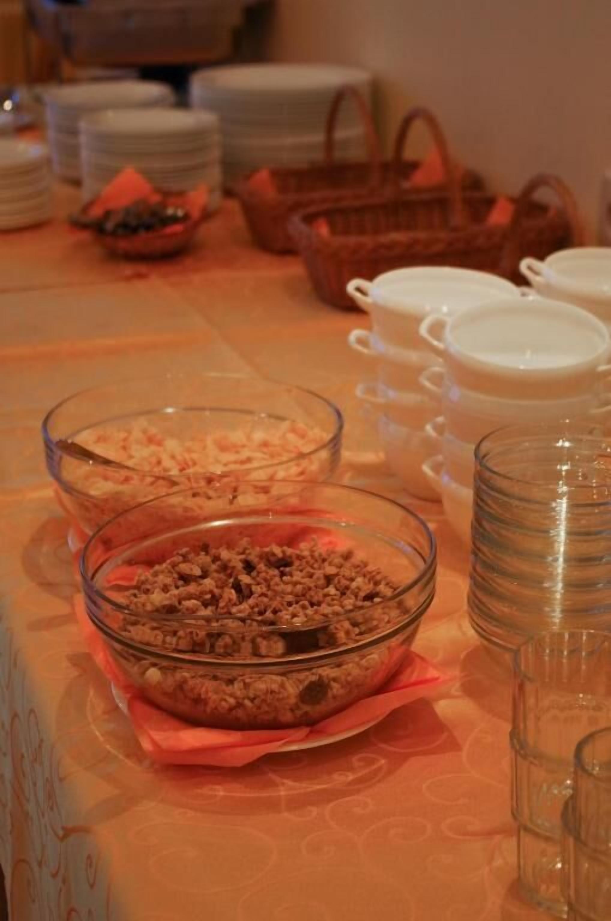 A buffet table with various food items and stacked plates.