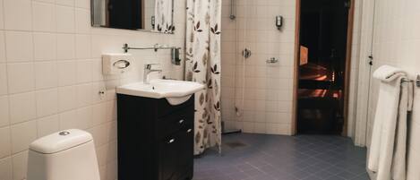 A bathroom with a toilet, sink, and shower.