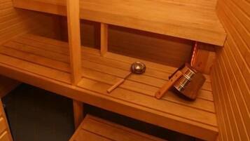 Una sauna con bancos de madera y un recipiente de metal.
