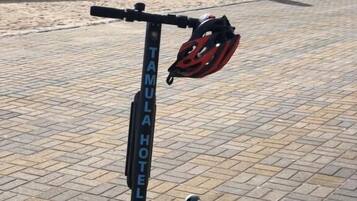 A stationary electric scooter with a helmet on the ground.