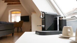 Une cuisine moderne équipée d’une machine à café, d’un distributeur d’eau et d’une tasse posée sur le comptoir.