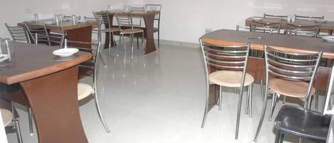 A conference room with multiple tables and chairs, arranged in a U-shape.