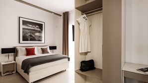 A modern bedroom with a bed, bedside tables, a wardrobe, and a framed picture on the wall. - Urban Isle (Gzira)