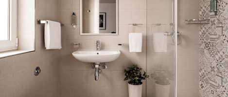 Een moderne badkamer met toilet, wastafel en douche.