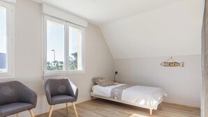 A bedroom with a bed, two chairs, a window, and a 'BEACH' sign on the wall. - Large house with pond and sea view, near the Lighthouse, garden and terraces, parking (Gatteville-le-Phare)