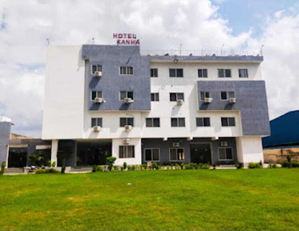 Un hotel de varios pisos con techo plano, unidades de aire acondicionado y un letrero que dice "HOTEL KANHA".