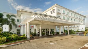 Ein modernes Hotel mit überdachter Eingangspartei, einer Rezeption und einem Parkplatz.