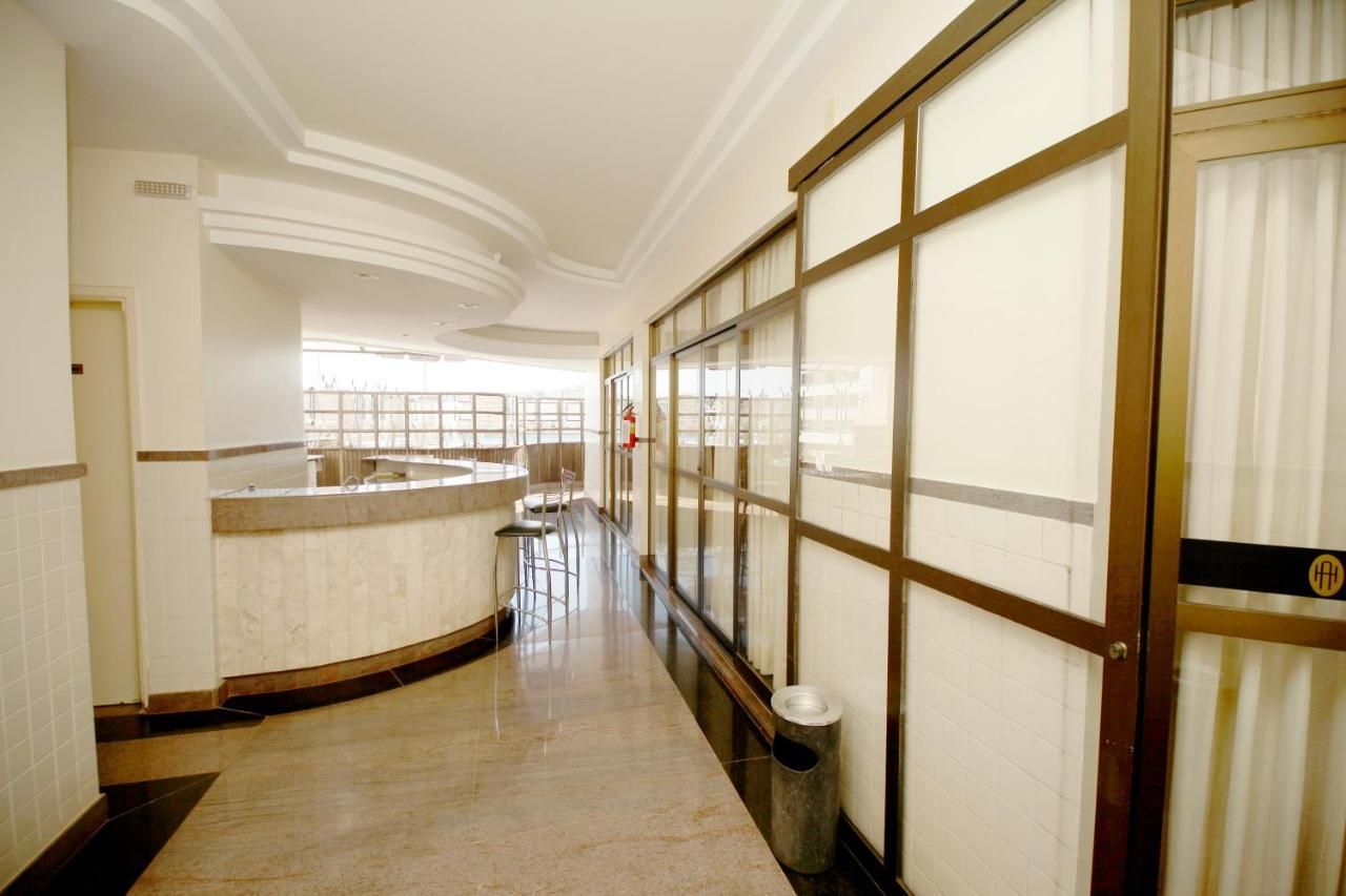 Ein Hotelkorridor mit einem gebogenen Empfangstresen, einem Mülleimer und einem großen Fenster mit Blick.